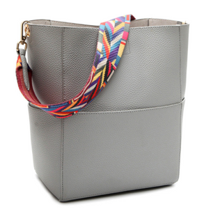 Solid color leather bucket bag with a color strap