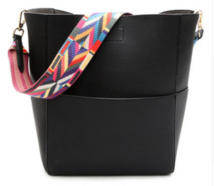 Solid color leather bucket bag with a color strap